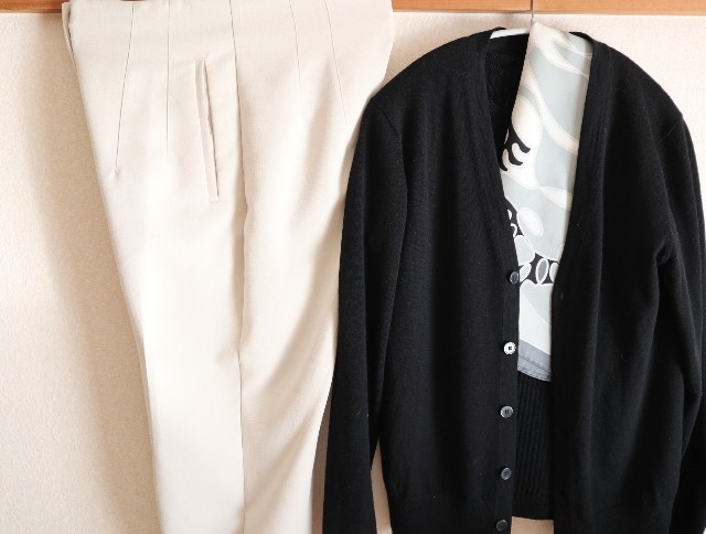 女性ミニマリストの通勤服　オフィスカジュアル（白パンツ、黒ニット、モノトーンスカーフ）の写真